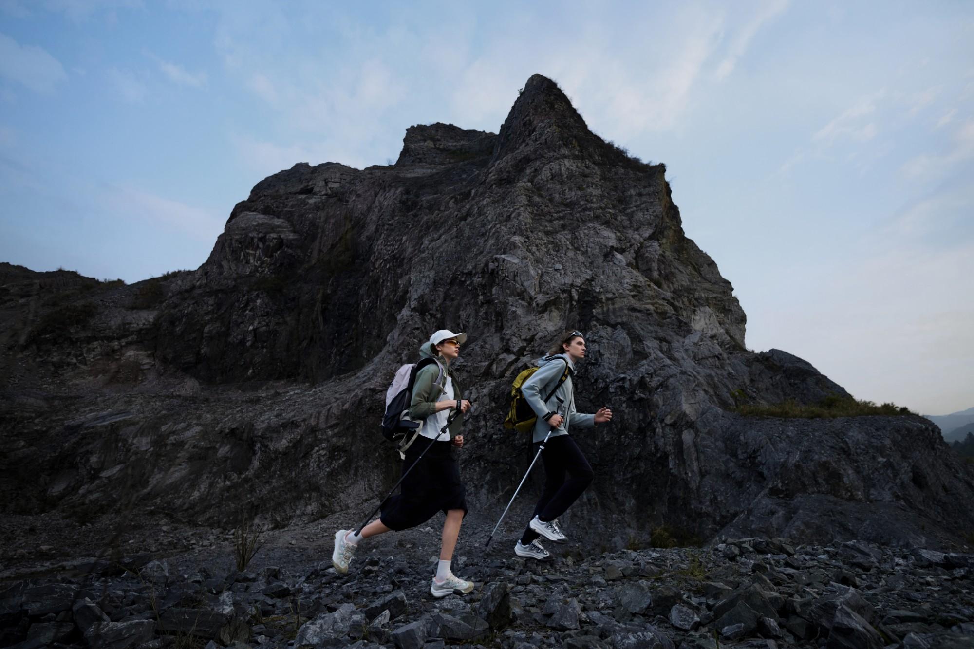 Two walkers on a scree slope at dusk